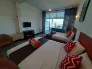 a hotel room with two beds and a television at Green Villa Ella in Ella