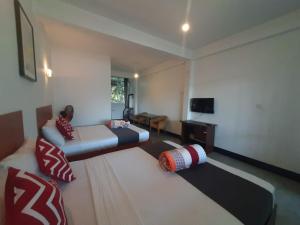 a living room with a bed and a television at Green Villa Ella in Ella