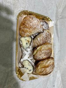 a container filled with bread and cheese on a table at Casa Malù in Torre Annunziata +13 photos