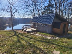 a small cabin on the side of a lake at Petite maison vue sur Lac de la Triouzoune Neuvic in Neuvic
