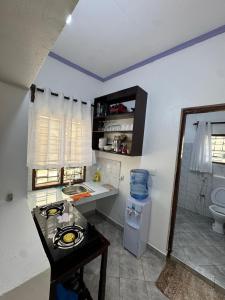 a small kitchen with a sink and a toilet at nova nest in Watamu +5 photos