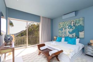 a bedroom with a large bed and a large window at Luxury 8-Suite Villa with Heated Pools, Ocean & Mountain Views in Cape Town +222 photos