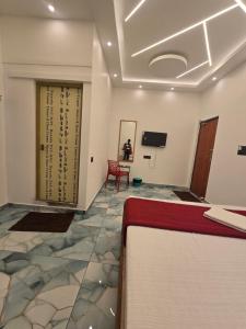 a room with a bed and a table and a tv at Divine Beach Resorts in Pondicherry