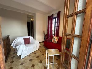 a living room with a red couch and a chair at La casa di Carlotta in Loano