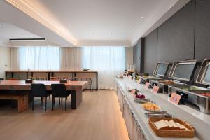 a restaurant with a buffet line with food on display at 花祺巨幕影院酒店 儋州那大镇夏日广场汽车站店 in Danzhou +31 photos