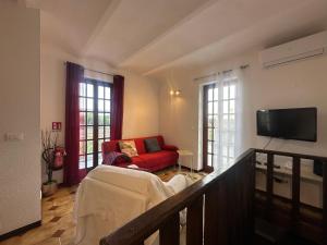 a living room with a red couch and a tv at La casa di Carlotta in Loano