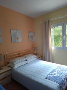 a bedroom with a large bed and a window at Lagonissi Summer House in Lagonissi
