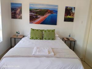a bedroom with a white bed with two side tables at Alikho luxury accommodation in Abisai