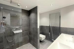 a bathroom with a shower and a toilet and a sink at Ferienwohnung Goede Tiid in Tinnum