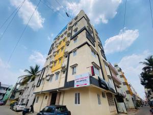 a tall building with yellow and white at Hotel Safko Suites in Bangalore