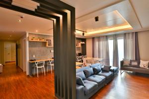 ein Wohnzimmer mit einem blauen Sofa und einer Küche in der Unterkunft Ezstay-Nampo in Busan