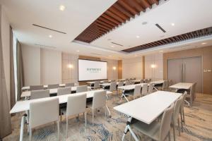 a conference room with tables and chairs and a screen at Somerset Valero Makati in Manila +22 photos