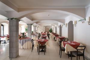 a restaurant with tables and chairs with red tablecloths at TH Borca di Cadore - Park Hotel Des Dolomites in Borca di Cadore