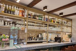 a bar with a lot of bottles and glasses at Bagoly-kő Panzió - Mátra Túraközpont in Parádsasvár
