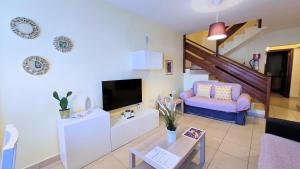 a living room with a couch and a tv at Evita Beach Suites Exclusivas in Caleta de Sebo