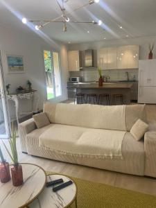 a living room with a couch and a kitchen at Appartement jardin in Le Cannet