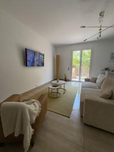 a living room with a couch and a table at Appartement jardin in Le Cannet