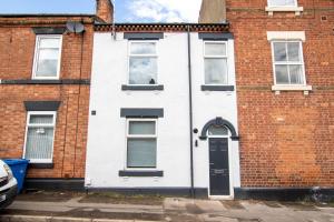 a red brick house with a black door at Camden St Accommodation in Derby