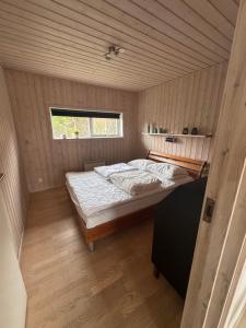 a bedroom with a bed in the middle of it at Marielyst feriehus in Bøtø By