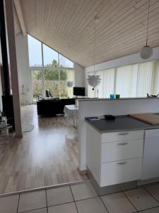 a kitchen and living room with a couch and a table at Marielyst feriehus in Bøtø By