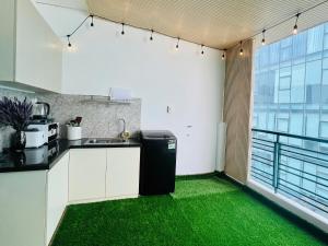 a kitchen with green flooring in a room with a window at Pony Bliss Haven - Sư Vạn Hạnh in Ho Chi Minh City +10 photos