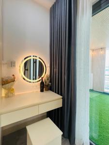 a bathroom with a mirror and a sink and a window at Pony Bliss Haven - Sư Vạn Hạnh in Ho Chi Minh City