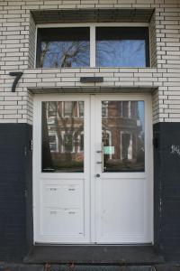a large white door in a brick building at Schönes Zimmer im Zentrum - 2 in Paderborn