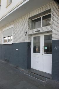 a white door on the side of a brick building at Schönes Zimmer im Zentrum - 2 in Paderborn +5 photos