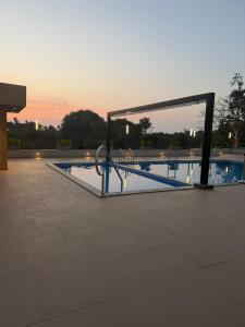 an empty swimming pool at dusk with the sunset at La Fenice Resort Madh Island in Mumbai +11 photos