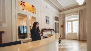 a woman standing in front of a counter in a room at TH Borca di Cadore - Park Hotel Des Dolomites in Borca di Cadore