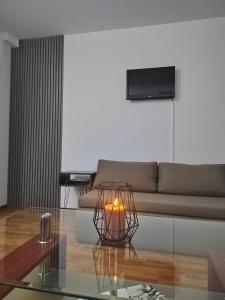 ein Wohnzimmer mit einer Couch und einer Kerze auf einem Glastisch in der Unterkunft Villa Old Town in Ohrid