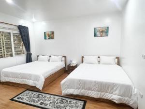 two beds in a room with white walls at Khế Homestay Phố Cổ Ninh Bình in Ninh Binh