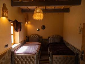 a room with two beds and a chandelier at Lodge bio berber nomad in Nkob
