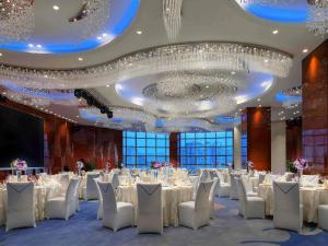 a large banquet hall with white tables and chairs at Sofitel Guiyang Hunter in Guiyang +120 photos