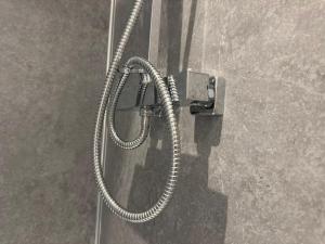 a shower with a hose attached to a wall at Camden St Accommodation in Derby +69 photos