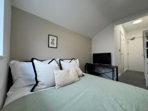 a bedroom with a bed with pillows and a television at Camden St Accommodation in Derby