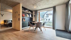 a room with a table and chairs and a bedroom at Haus am FELS Steinbrech in Hermagor