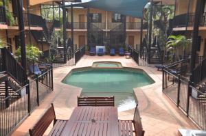 a patio area with a pool table and chairs at Apartments at Blue Seas Resort in Broome