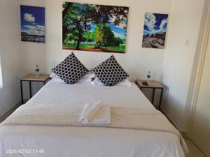 a bedroom with a white bed with two side tables at Alikho luxury accommodation in Abisai +12 photos