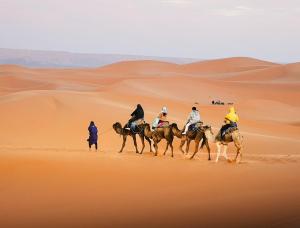 a group of people riding horses in the desert at Lantern Luxury Camp in Merzouga