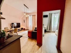 a living room with red walls and a living room with a table at Le Kozy - Appartement 2 pièces climatisé au coeur de Vendôme avec parking in Vendôme