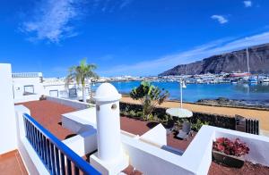 a balcony with a view of the water and a harbor at Evita Beach Suites Exclusivas in Caleta de Sebo
