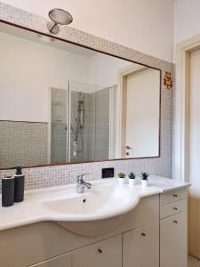 a bathroom with a sink and a large mirror at Apartment near Lake Como -300m to station -AC in Valmadrera