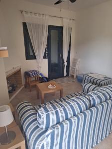a living room with two blue and white striped couches at Hill View in Nikiti
