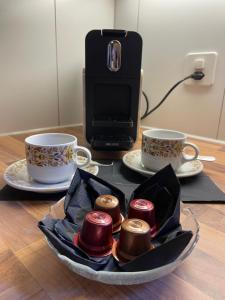a tray of chocolates on a table with two cups at Gemütliche 3,5 Zimmer Wohnung in Unterseen