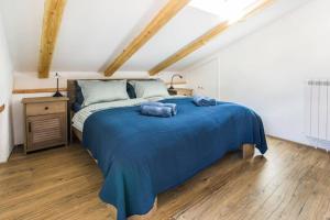a bedroom with a large bed with blue sheets at Apartma Luna with mountain view in Kobarid