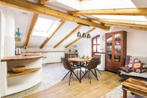 a kitchen with a table and chairs in a room with wooden ceilings at Apartma Luna with mountain view in Kobarid +12 photos