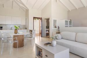 a white living room with a couch and a table at Magganos Sunset Villas in Fiskardo
