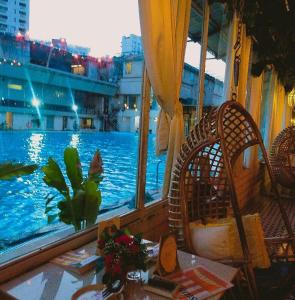 a view of a pool from a balcony with a table and chairs at The Thane Club in Thane