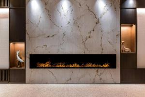 a fireplace in a room with a white wall at Rosa Grand Milano - Starhotels Collezione in Milan